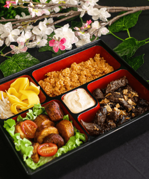 Savane & Mousson - Bento Djolof avec riz tieb rouge, bœuf sauté aux oignons, mangues vertes avec pousses de soja, et plantains